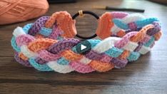 a colorful crocheted bracelet sitting on top of a wooden table