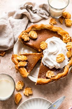 there is a pie with whipped cream on the top and pecans in the background