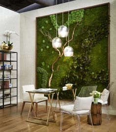 a living room with white chairs and a moss covered wall behind the chair is a dining table