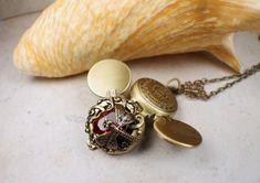 a close up of a clock on a chain near a seashell and sea shell