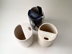 three white and black cups sitting on top of a table