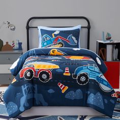 a child's bed with cars and trucks on it, in a bedroom setting