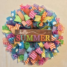 a colorful wreath with the word hello summer on it and lots of ribbons around it