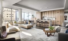 a living room filled with furniture next to a kitchen