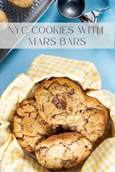 chocolate chip cookies with mars bars in a basket on top of a blue tablecloth