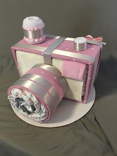 a cake made to look like a camera with pink and silver trimmings on it