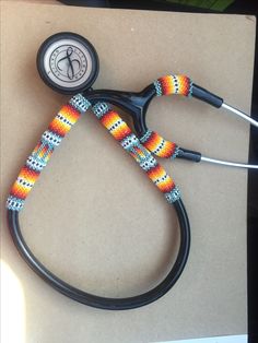 a medical stethoscope with an orange, yellow and blue beaded cord