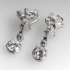 These gorgeous dangle style pierced earrings are each accented with five (5) prong set round brilliant cut diamonds and four (4) channel set baguette cut diamonds. The earrings measure 33.4mm in length and are finished with omega style backs. Platinum Diamond Earrings With Baguette Diamonds For Formal Events, Platinum Diamond Earrings With Baguette Diamonds For Formal Occasions, Platinum Diamond Earrings With Baguette Cut For Formal Occasions, Classic Baguette Diamond Earrings For Formal Occasions, Formal Platinum Diamond Earrings Baguette Cut, Formal Baguette Cut Platinum Diamond Earrings, Classic Formal Earrings With Baguette Diamonds, Classic Clip-on Diamond Earrings, Elegant Platinum Earrings With Baguette Diamonds