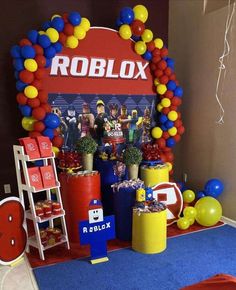 a room with balloons and decorations on the floor, including a sign that says roblox