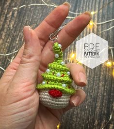 a crocheted christmas tree ornament being held by someone's hand