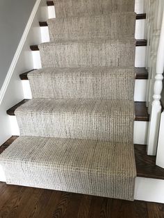 a carpeted staircase with wooden handrails and white balconies on the bottom