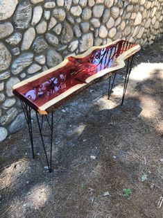 a wooden bench sitting next to a stone wall