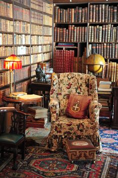 a chair in front of a bookshelf filled with lots of bookcases