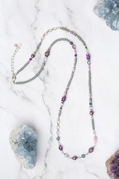 Experience the beauty and versatility of the Reflections Collection. Each piece is thoughtfully handcrafted using carefully chosen materials. This collage necklace measures 29.5-31.5" and is completed an antique silver plated brass extender chain and lobster claw clasp. Elevate your style with Reflections. Antique Silver Plated Brass (lead and nickel free) Amethyst, Blue Lace Agate, Pearl 29.5-31.5", adjustable with antique silver plated brass lobster claw clasp We hand select our natural materi Artisan Silver Crystal Necklaces With Gemstone Beads, Silver Agate Crystal Necklace With Gemstone Beads, Silver Agate Gemstone Beaded Necklaces, Bohemian Silver Long Necklace With Gemstone Beads, Silver Agate Gemstone Beaded Necklace, Silver Beaded Agate Necklaces With Natural Stones, Handmade Unique Amethyst Beaded Necklaces, Spiritual Silver Single Strand Crystal Necklace, Silver Single Strand Amethyst Necklace