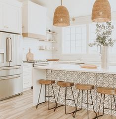 a kitchen with three stools next to an island