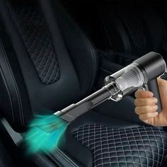 a person is holding a car vacuum in their hand and spraying it with green light