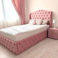 a bedroom with pink furniture and curtains