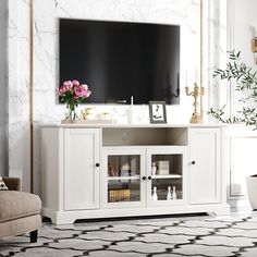 a living room scene with focus on the entertainment center and large screen tv mounted to the wall