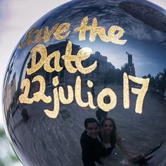 the reflection of two people in a shiny ball that says save the date july 17