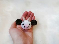 a hand is holding a small crocheted animal