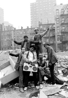 a group of men standing next to each other on top of a pile of rubble