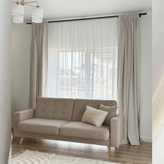 a beige couch sitting in front of a window