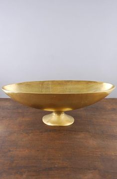 a golden bowl sitting on top of a wooden table