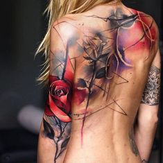 the back of a woman's body with tattoos on her chest and flowers painted on it