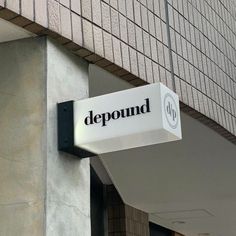 a sign on the side of a building that says, deponund in black and white