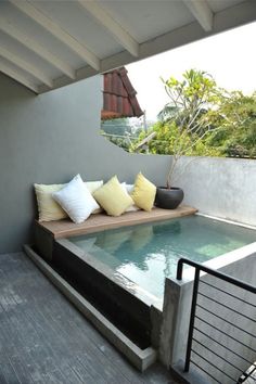 an outdoor pool with pillows on the edge