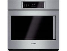 a stainless steel oven with the door open and its light on, in front of a white background