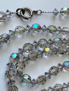 This is a beautiful vintage 1930's iridescent crystal bead long necklace.  The necklace measures 62 inches long. Each bead measures 7 mm. This necklace is chain strung and he has an old-fashioned spring ring clasp.  The aurora borealis finish is not overpowering. It is very subtle. This is an absolutely gorgeous piece. This item is an excellent preowned vintage condition with normal wear for the age Antique Dishes, Iridescent Crystal, Crystal Bead Necklace, The Aurora, Bead Necklace, Spring Rings, Long Necklace