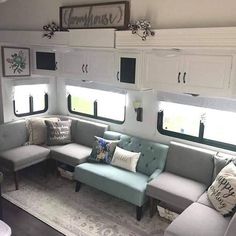 a living room filled with furniture and lots of white cupboards next to a window