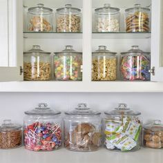 the shelves are filled with many different types of cookies and candies in glass jars