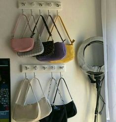 several purses hanging from hooks on a wall