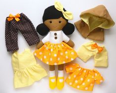 an assortment of dolls and clothing on a white surface