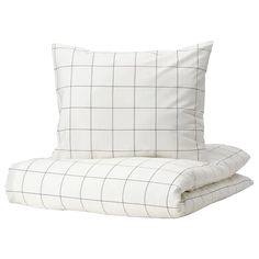 two pillows sitting next to each other on top of a white bed sheet with black and white checkered pattern