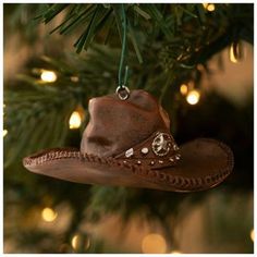 a cowboy hat ornament hanging from a christmas tree