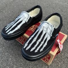 This pair of custom all black Vans feature our Skeleton Bones design. Various sizes available. Canvas uppers. Vulcanized waffle rubber outsoles. Paint is 100% permanent and will never come off. Made in the USA.   Want Black Vans Slip ons with a white rubber midsole? Check these out: https://www.etsy.com/listing/177630379/hand-painted-skeleton-boney-feet-slip-on?ref=shop_home_feat_1&frs=1 We buy each pair of shoes BRAND NEW from the Vans retail store. Each pair is made to order, please make sure you put in the correct shoe size before you check out. The ink is permanent and will never come off. Made in the USA. This price includes everything: shoes, artwork, and shipping. Thanks for stopping by our Etsy shop! Please message us with any questions! Because the artwork is custom made for you, Custom Slip-on Sneakers With Studded Outsoles For Streetwear, Custom Slip-on Sneakers With Vibram Sole For Streetwear, Black Custom Slip-on Sneakers For Streetwear, Black Slip-on Custom Sneakers For Streetwear, Skeleton Vans, Custom Slip On Vans, Painted Skeleton, All Black Vans, Bones Design