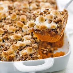 a close up of a spoon in a casserole dish with food on it