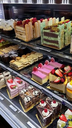 a display case filled with lots of different types of cakes and desserts on top of it