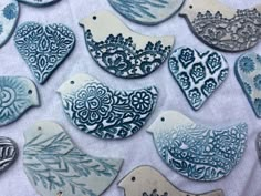 blue and white ceramic birds are on a tablecloth with other decorative items in the background