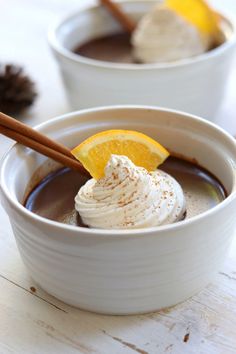 chocolate orange cinnamon pots de creme in a white bowl with an orange slice on top