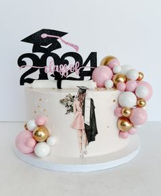 a graduation cake decorated with balloons and confetti