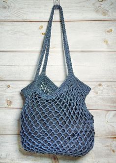 a crocheted bag hanging on a wooden wall with wood planks in the background