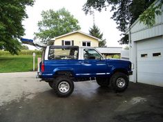 a blue pick up truck parked in front of a house