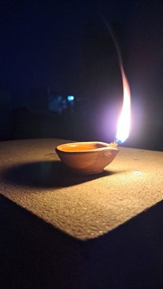 a small bowl sitting on top of a table with a lit candle in the middle