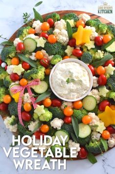 a platter filled with vegetables and dip on top of the words holiday vegetable wreath