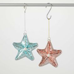 two starfish ornaments hanging from a metal rod