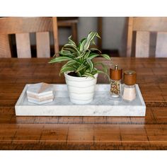 a marble tray with a potted plant and salt shakers sitting on top of it